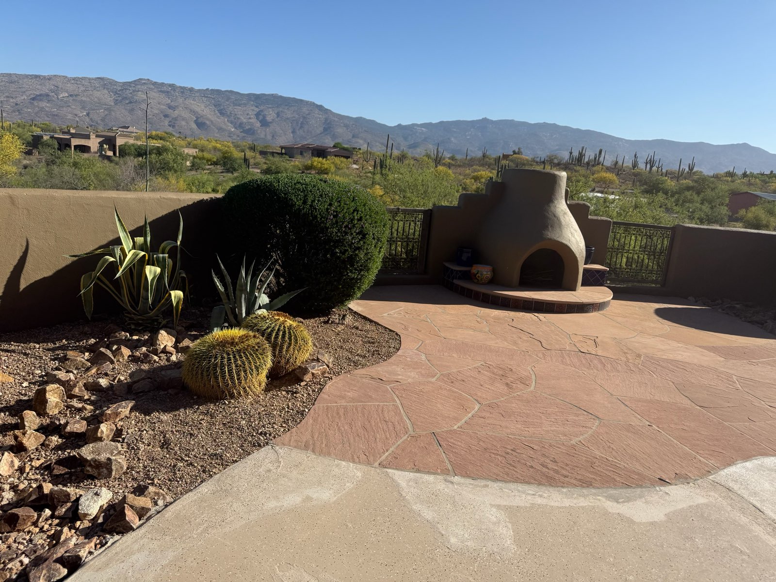 Finished desert patio with flagstone, kiva fireplace and agave below the Catalina foothills